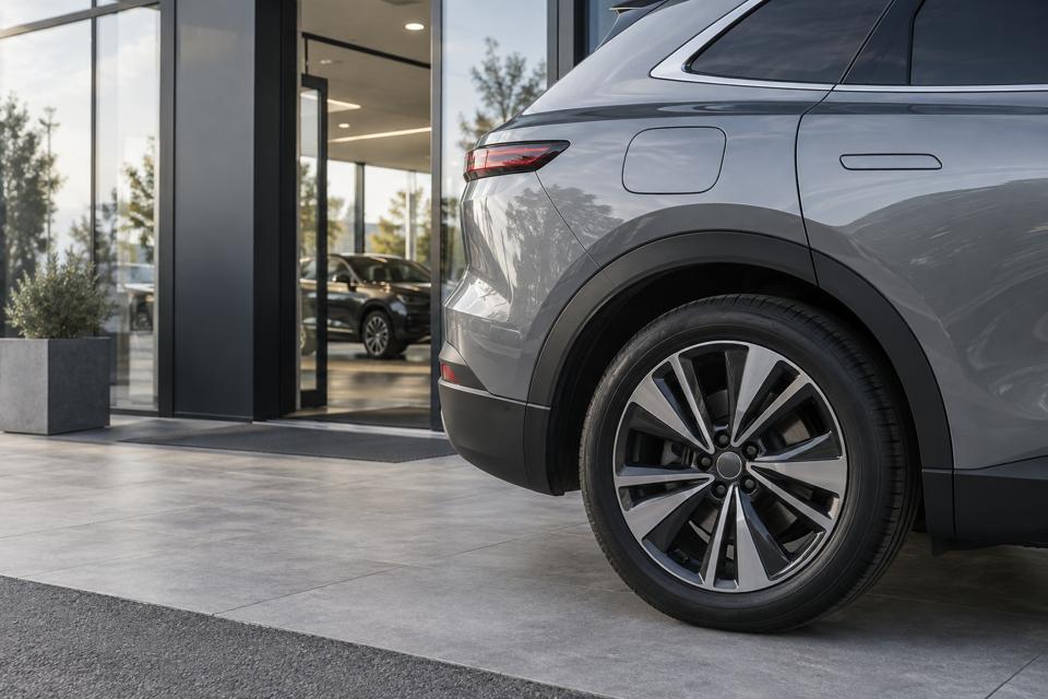 Hjul og side på en elektrisk SUV ved indgangen til et bilhus